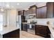 Updated kitchen with stainless steel appliances, granite counters, and ample dark wood cabinet storage at 5908 Giddings St, Raleigh, NC 27616
