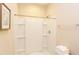 Bright shower featuring white tile, a showerhead, and storage, adjacent to the toilet at 5908 Giddings St, Raleigh, NC 27616