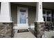 Elegant front door entrance framed by stone pillars and a charming 'Welcome' wreath, creating a warm invitation at 60 Falling Leaf Ln, Benson, NC 27504