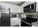 Bright kitchen featuring stainless steel appliances, white cabinetry, and granite countertops for modern appeal at 60 Falling Leaf Ln, Benson, NC 27504