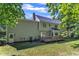 View of the home's back exterior featuring a deck, siding, door, brick chimney, and manicured lawn at 6201 Bayswater Trail Trl, Raleigh, NC 27612