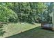 The backyard features a tiered deck, lush foliage, and a large grassy area at 6201 Bayswater Trail Trl, Raleigh, NC 27612