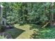 The home's backyard features a playground with slide, lush foliage, and a tiered deck at 6201 Bayswater Trail Trl, Raleigh, NC 27612