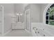 Bright bathroom features double sinks, a glass enclosed shower, and a jetted tub under an arched window at 6201 Bayswater Trail Trl, Raleigh, NC 27612