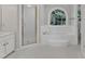 Bright bathroom features a glass shower and a jetted tub under a large arched window at 6201 Bayswater Trail Trl, Raleigh, NC 27612