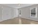 Bedroom features light walls, laminated flooring, two windows, and double door closets at 6201 Bayswater Trail Trl, Raleigh, NC 27612