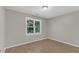 Bright room features light walls, laminated flooring and a large window with mature trees outside at 6201 Bayswater Trail Trl, Raleigh, NC 27612