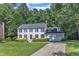 Traditional two-story home featuring gray siding, black shutters, and a well-manicured front lawn with mature trees at 6201 Bayswater Trail Trl, Raleigh, NC 27612