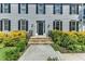 Close-up of the home's entrance with stone steps, black door, and decorative landscaping at 6201 Bayswater Trail Trl, Raleigh, NC 27612