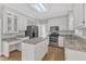 Bright kitchen boasts stainless appliances, granite counters, white cabinetry, and a center island at 6201 Bayswater Trail Trl, Raleigh, NC 27612