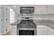 Bright kitchen features stainless steel appliances and white cabinetry with gray granite countertops at 6201 Bayswater Trail Trl, Raleigh, NC 27612