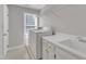 Clean laundry room featuring a sink, storage cabinets, and a window at 6201 Bayswater Trail Trl, Raleigh, NC 27612