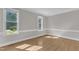 A well-lit room with hardwood floors, crown molding and large windows overlooking a well-manicured lawn at 6201 Bayswater Trail Trl, Raleigh, NC 27612