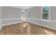 Bright living room with archway, hardwood floors, and natural light from large windows at 6201 Bayswater Trail Trl, Raleigh, NC 27612