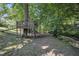 Scenic backyard with a wooden playset and a small stream, providing a serene outdoor space at 6328 Jones Farm Rd, Wake Forest, NC 27587