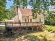 View of the back of the house with a large deck, stairs, and well-maintained yard at 6328 Jones Farm Rd, Wake Forest, NC 27587