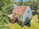 Exterior view featuring deck, brown roof, bay window, and stairs, amidst a lush yard at 6328 Jones Farm Rd, Wake Forest, NC 27587