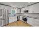 Modern kitchen with white cabinets, stainless steel appliances, and granite countertops at 6328 Jones Farm Rd, Wake Forest, NC 27587