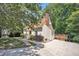 View of the home's exterior with a wide driveway and brick chimney, surrounded by lush trees at 6328 Jones Farm Rd, Wake Forest, NC 27587
