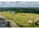 Aerial view of a golf course with lush greenery, scenic water features, and a view of a lake at 74 Permit Ct, Chapel Hill, NC 27517