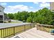 This home has a lovely wooden deck overlooking a large backyard with lush trees and a white fence at 74 Permit Ct, Chapel Hill, NC 27517