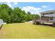 A spacious backyard featuring lush green grass with a white picket fence and a wooden deck at 74 Permit Ct, Chapel Hill, NC 27517