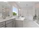 Bright bathroom featuring double vanity, soaking tub, a large window, and marble tile flooring at 74 Permit Ct, Chapel Hill, NC 27517