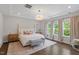 Elegant bedroom with tray ceiling, modern chandelier, large windows, and neutral decor at 74 Permit Ct, Chapel Hill, NC 27517