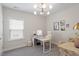Well-lit home office with a modern desk setup and a stylish chandelier at 74 Permit Ct, Chapel Hill, NC 27517