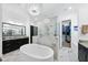 This bathroom features dual vanities, a standalone tub, a glass-enclosed shower, and a walk-in closet at 7545 Hasentree Club Dr, Wake Forest, NC 27587
