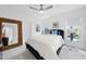 Bright bedroom with a large woven mirror, ceiling fan and neutral color scheme at 7545 Hasentree Club Dr, Wake Forest, NC 27587