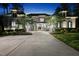Elegant stone home featuring a wide driveway, manicured landscaping, and sophisticated exterior lighting at 7545 Hasentree Club Dr, Wake Forest, NC 27587