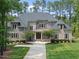 Stately two-story home featuring brick and stone accents, a well-manicured lawn, and a welcoming walkway at 7545 Hasentree Club Dr, Wake Forest, NC 27587