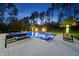Resort-style pool with waterfall features, a hot tub, lounge chairs, and ambient outdoor lighting at 7545 Hasentree Club Dr, Wake Forest, NC 27587