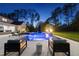Sparkling pool at dusk with modern seating and lounge chairs in a private backyard setting at 7545 Hasentree Club Dr, Wake Forest, NC 27587