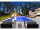 Luxury backyard pool at dusk with waterfall feature, lounge chairs, and landscape lighting at 7545 Hasentree Club Dr, Wake Forest, NC 27587