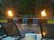 An outdoor pool with fire bowls and a multi-tiered water feature surrounded by chaise lounges at 7545 Hasentree Club Dr, Wake Forest, NC 27587