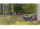 Spacious backyard featuring a well-maintained lawn, mature trees, and grilling area, perfect for outdoor entertainment at 8132 Wheeler Woods Dr, Apex, NC 27539