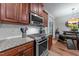 Modern kitchen with stainless steel appliances, granite countertops, and sleek white backsplash at 8132 Wheeler Woods Dr, Apex, NC 27539