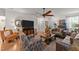 Open-concept living room with hardwood floors, a ceiling fan, and stylish furnishings at 8132 Wheeler Woods Dr, Apex, NC 27539