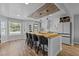 Sunlit kitchen featuring a large island with seating, updated appliances, and wood plank flooring at 820 Water Plant Rd, Zebulon, NC 27597