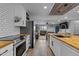 Open kitchen featuring a butcher block island, stainless steel appliances, and subway tile backsplash at 820 Water Plant Rd, Zebulon, NC 27597