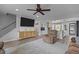 Open-concept living room with ceiling fan flows into modern kitchen with island and light wood flooring at 820 Water Plant Rd, Zebulon, NC 27597