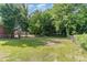 Large backyard with mature trees, lush grass, and a chainlink fence at 828 Cotton Pl, Raleigh, NC 27601