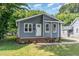 Cozy gray home with a brick foundation, a well manicured lawn, and flowering landscaping at 828 Cotton Pl, Raleigh, NC 27601