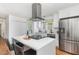 Modern kitchen features white cabinets, countertops, a large island, stainless appliances, and hardwood floors at 828 Cotton Pl, Raleigh, NC 27601