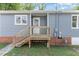 Rear view of a home featuring wood stairs leading to a wooden porch and a white door at 828 Cotton Pl, Raleigh, NC 27601