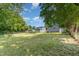 Backyard view of the property featuring a large yard with fence and lush trees at 828 Cotton Pl, Raleigh, NC 27601
