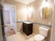 Well-lit bathroom featuring tiled floors, vanity with dark wood cabinets, and an accessible doorway at 90 Oak Leaf Ln, Chapel Hill, NC 27516