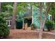 Charming home with green siding, wooden stairs to the front door, and mature trees at 90 Oak Leaf Ln, Chapel Hill, NC 27516